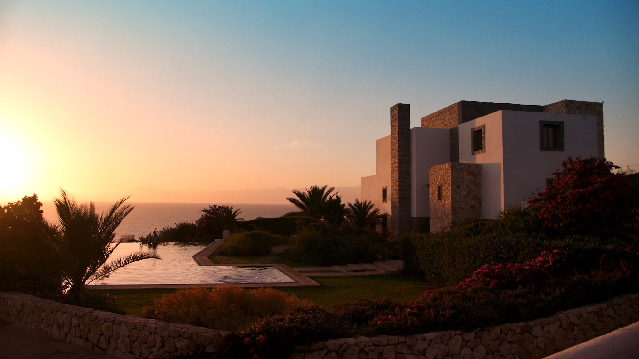 Küste von Paphos bei Sonnenuntergang mit moderner Villa und Infinity-Pool
